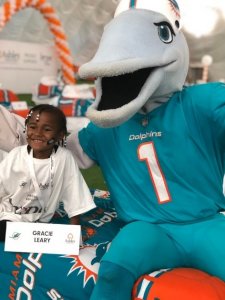Child posing with Miami Dolphins mascot T.D.