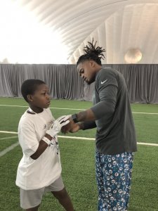 Dolphins player giving child a practice glove.
