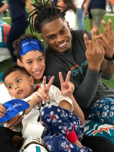 Dolphins player posing with kids in the Bubble.