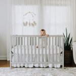 Baby standing in crib.