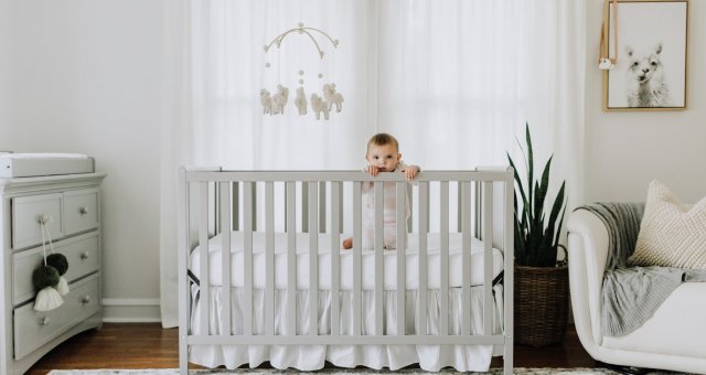 Baby standing in crib.