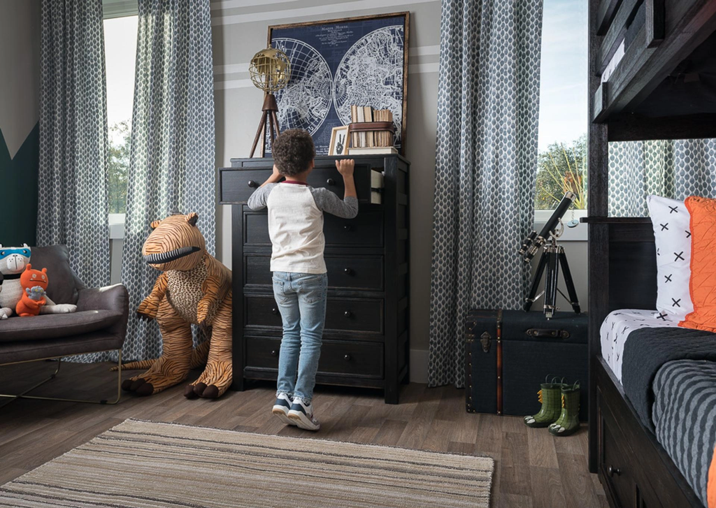 Kid opening dresser anchored to wall